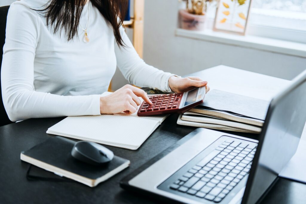 Account balance definition. Female Accountant working with laptop and calculator in office.
